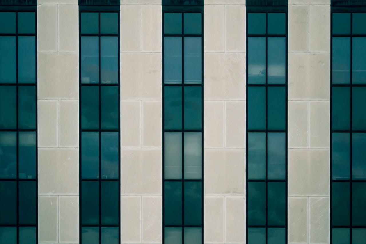 Symmetrical facade of a modern building showcasing glass and concrete patterns.